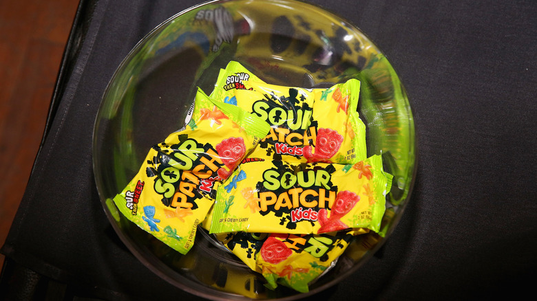 A bowl containing several snack-sized packages of Sour Patch Kids