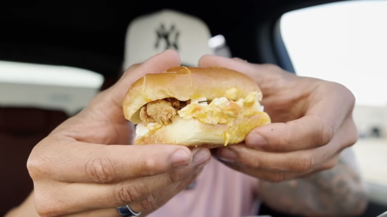 Hands holding a KFC Snacker.