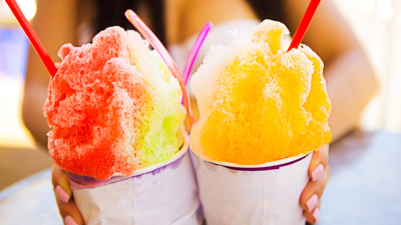 Two cups of shaved ice with flavored syrups.