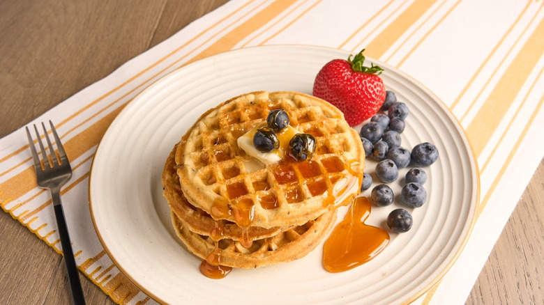 Jimmy Dean Protein Blueberry Waffles prepared on a plate with berries, butter, and syrup