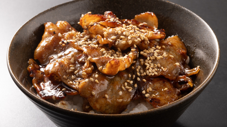 A bowl of pork Donburi is on a table.