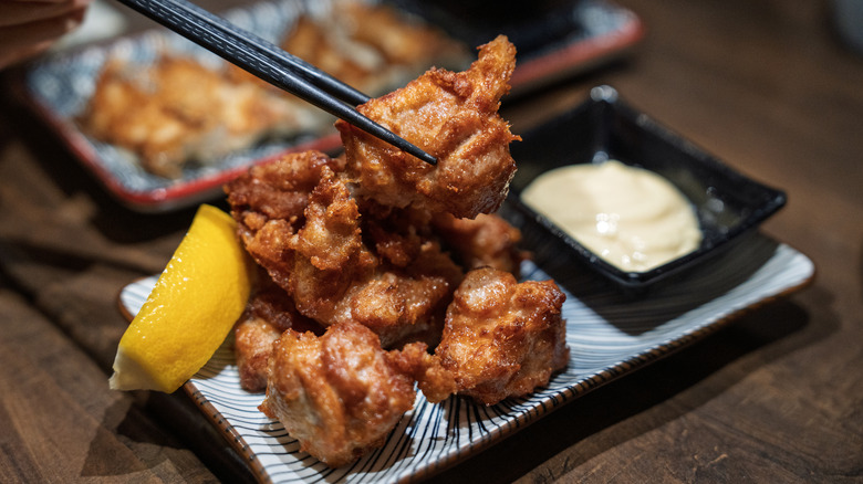 A person uses chopsticks to pick up a piece of kaarage
