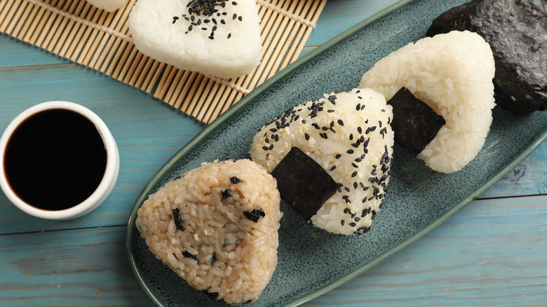 A variety of onigiri are on a blue plate.