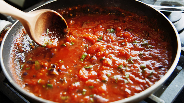 pasta sauce in pan with wooden spoon
