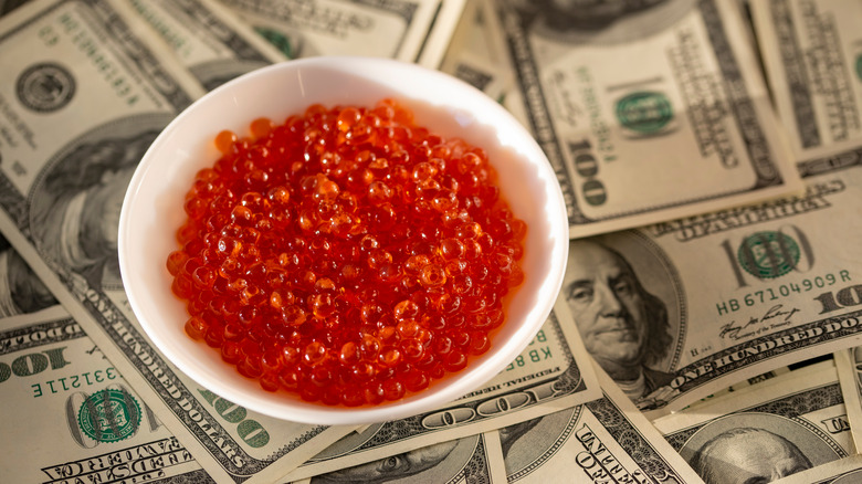 bowl of red caviar on banknotes