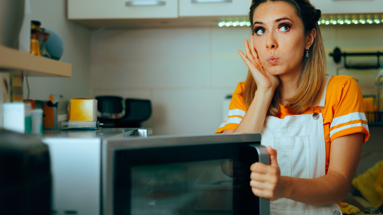 Woman opening the microwave door