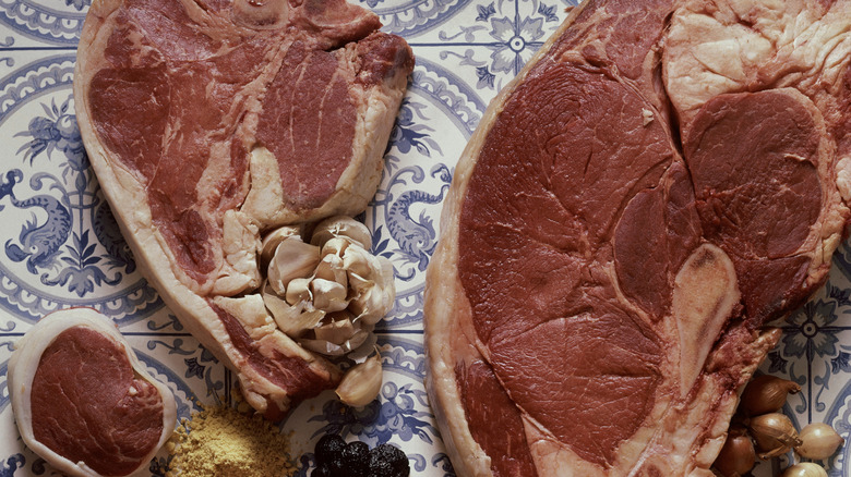 close up of large cuts of pork chop on blue patterned table