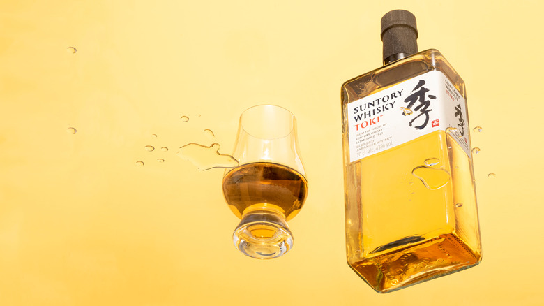 a bottle and class of Suntory whisky from below