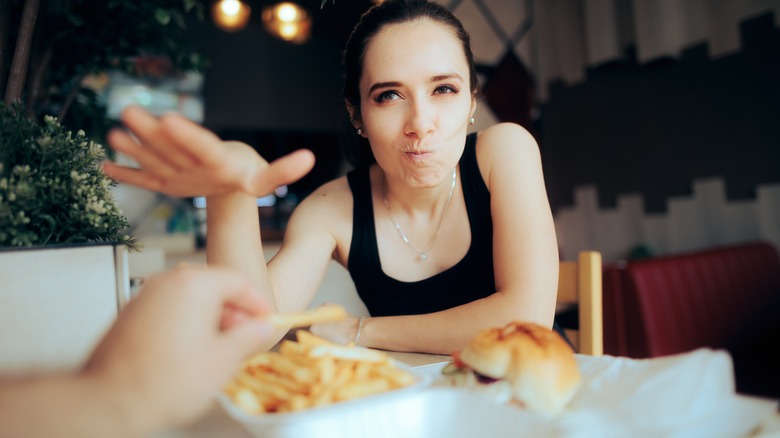 girl putting hand over french fries