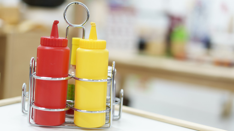 Ketchup and mustard squeeze bottles in a silver caddy