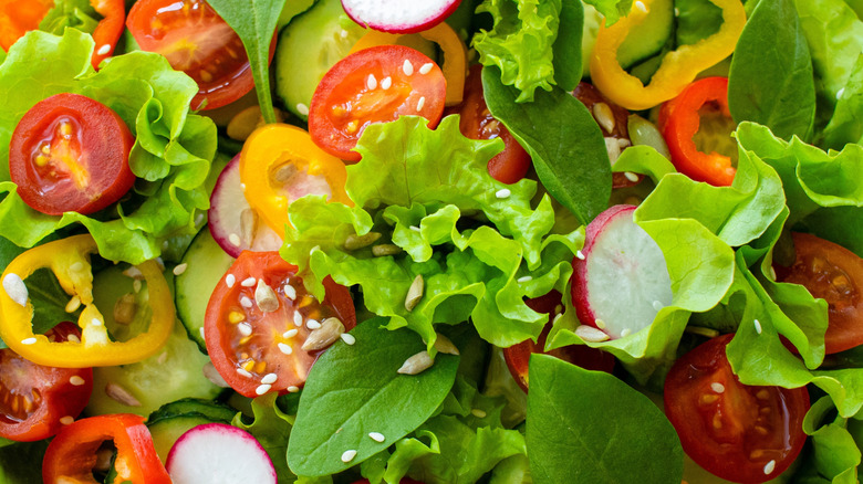 Salad greens tossed with sliced peppers, radishes, and tomatoes