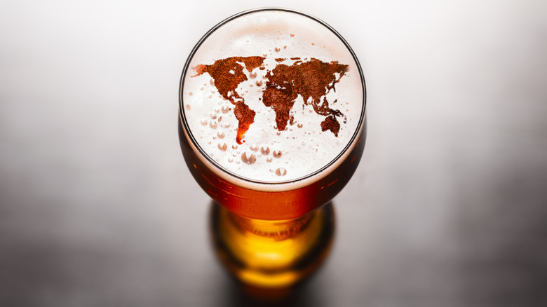 World map outlined by foam in a full pint of beer seen from above