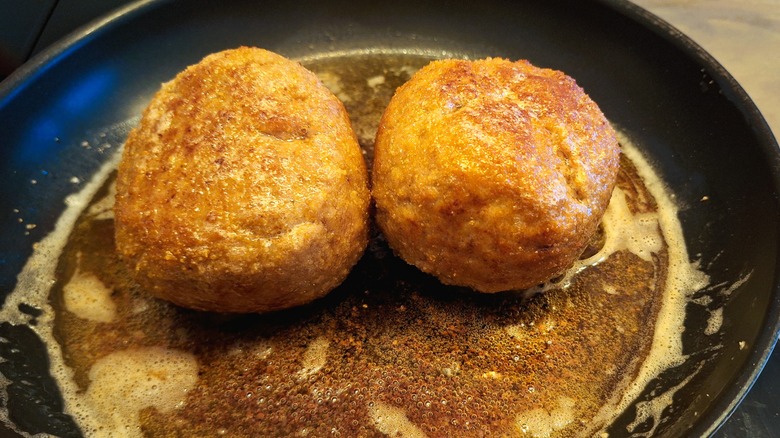 fried food in a hot pan with brown butter sauce