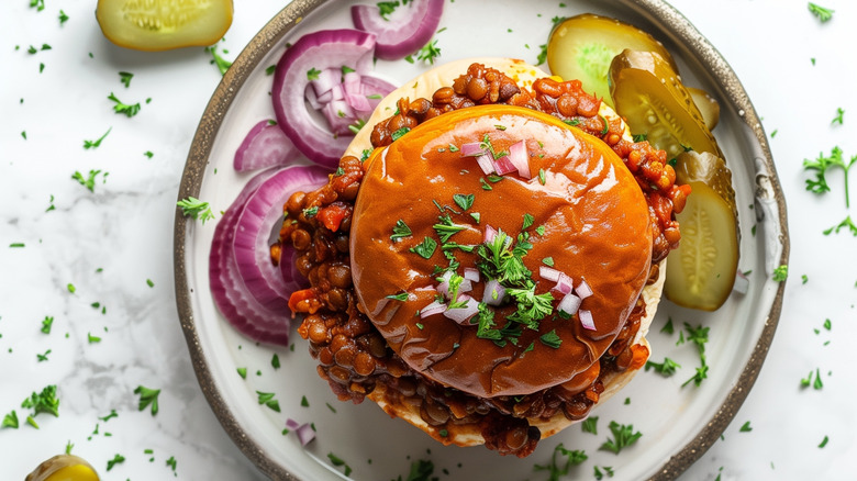 sloppy joe with pickles on a plate