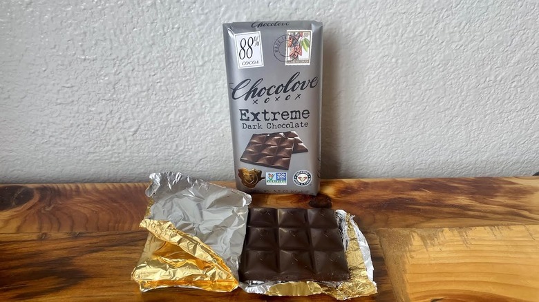 An unwrapped Chocolove 88% Extreme Dark Chocolate Bar on a wooden table top