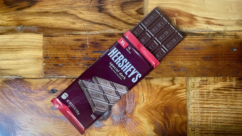 A partially unwrapped Hershey's Special Dark Chocolate Bar lying on a wooden table top