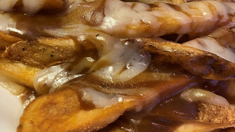 Close-up of fries covered in melted cheese and brown gravy