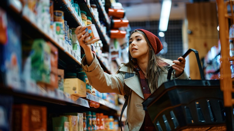 young woman holding canned food