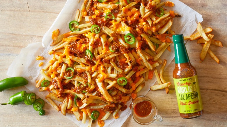 Chunky Garlic & Jalapeño Hot Sauce from Trader Joe's alongside a baking pan of smothered fries.