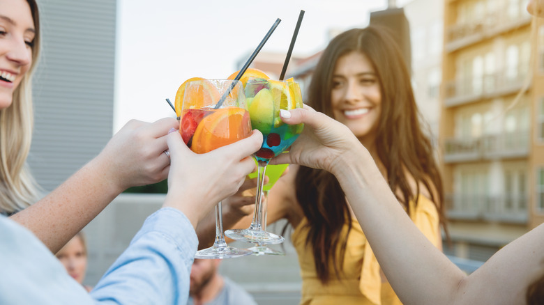women toasting fruity cocktails