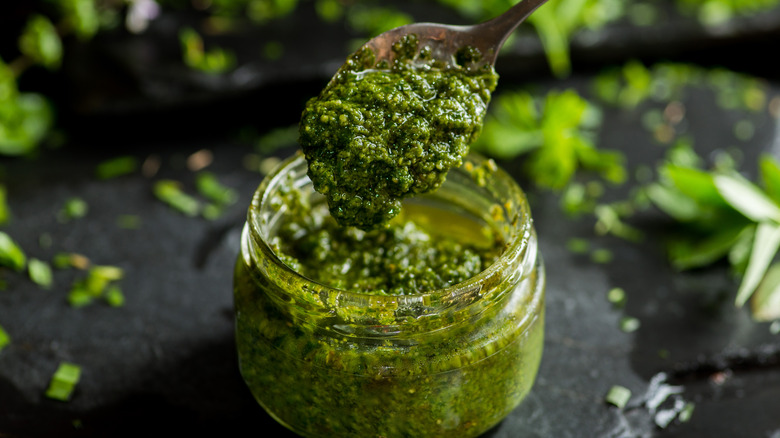 Jar and spoon of pesto