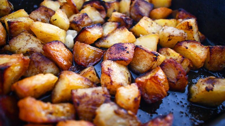 close up of potatoes cooking on a pan