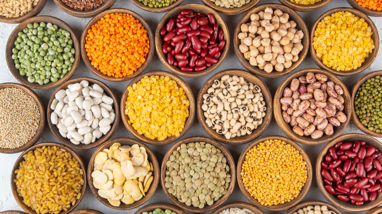 multiple small bowls filled with various types of colorful grains and legumes