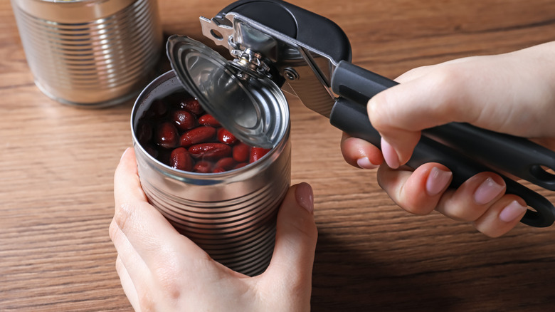 Hands opening a can of beans