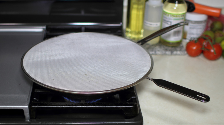 Splatter shield on top of a pan on the stove