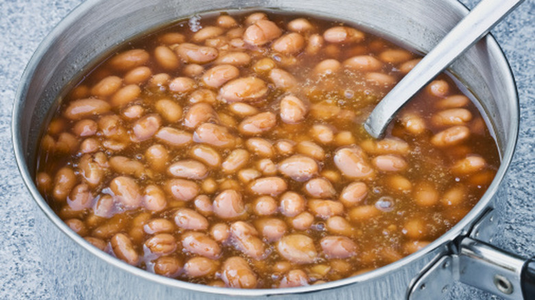 Frying pan full of pinto beans in liquid