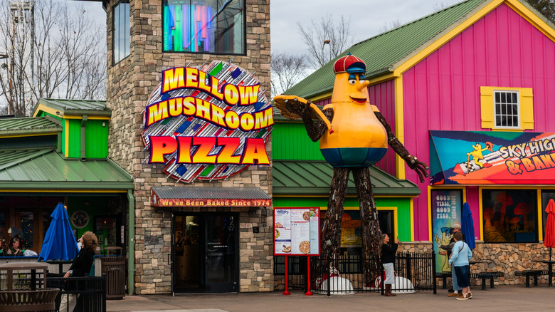 An exterior of Mellow Mushroom Pizza with a large statue of a mascot outside.