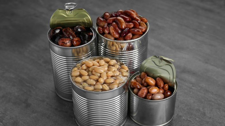 Open cans of beans of assorted sizes