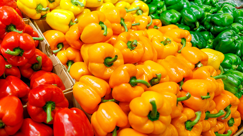 Red, orange, and green bell peppers at a store