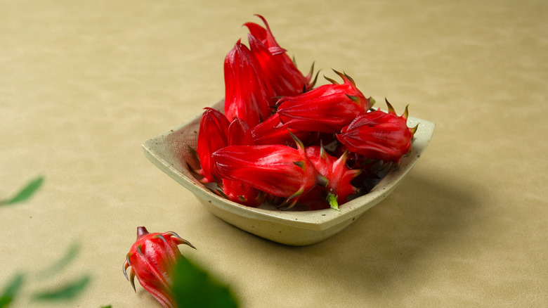 Several Jamaican sorrel hibiscus calyces are stacked in a small bowl