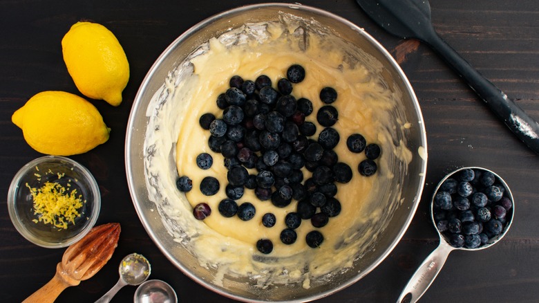Berries and lemon zest next to bowl of batter
