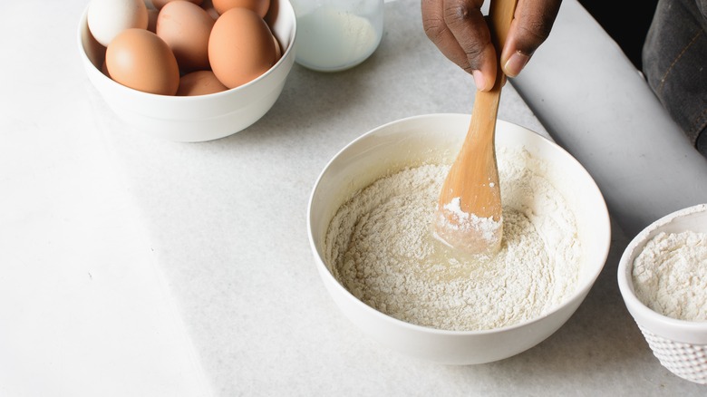 Wooden spoon stirring batter in bowl