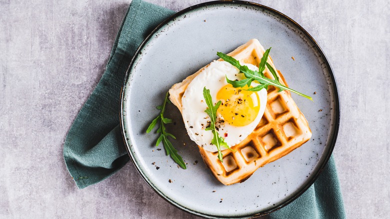 Fried egg on a waffle with greens