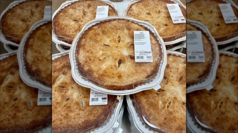 One apple pie sits on top of others in a stack in Costsco
