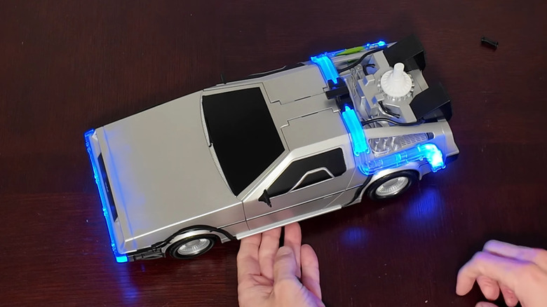 Hands hold a "Back to the Future" DeLorean replica popcorn container