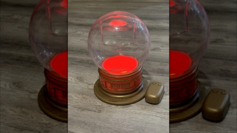 A "Red One" snow globe popcorn holder is lit up with red light