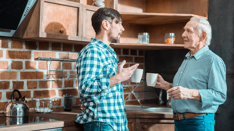 Millennial and boomer men having a conversation in a kitchen