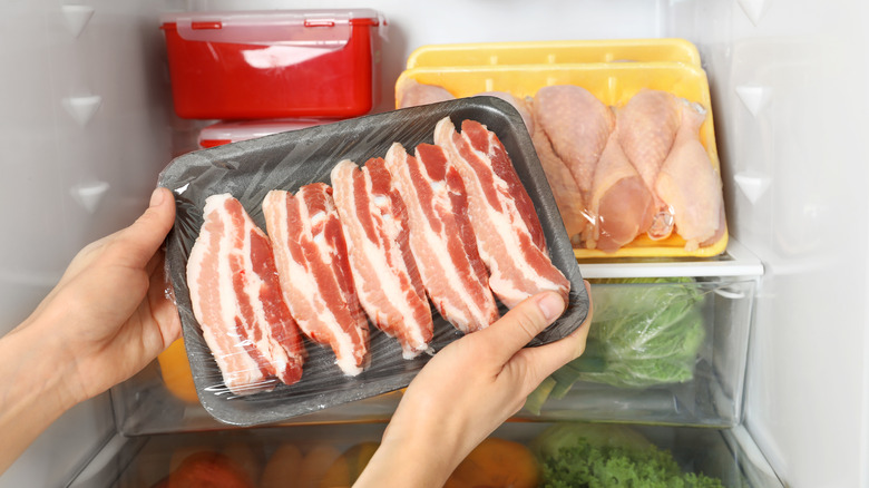 woman taking bacon from fridge