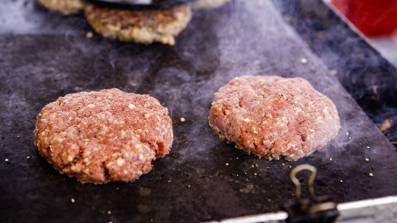 Raw burgers on grill