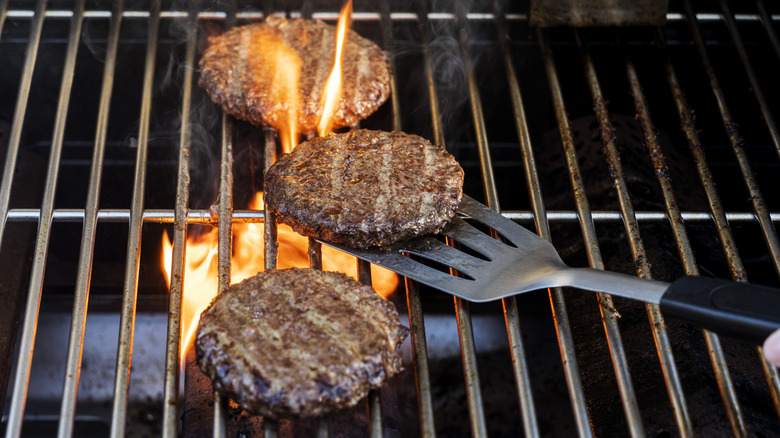 Spatula flipping burger on grill