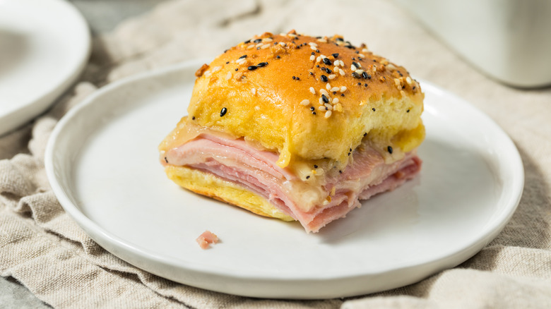 A ham and cheese slider sits on a plate