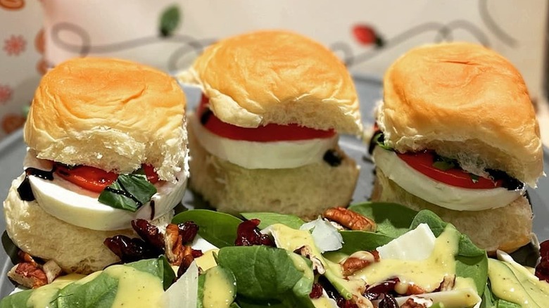 Caprese sliders sit on a plate.
