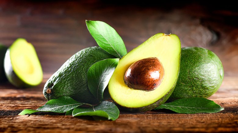 half avocado on a wooden board