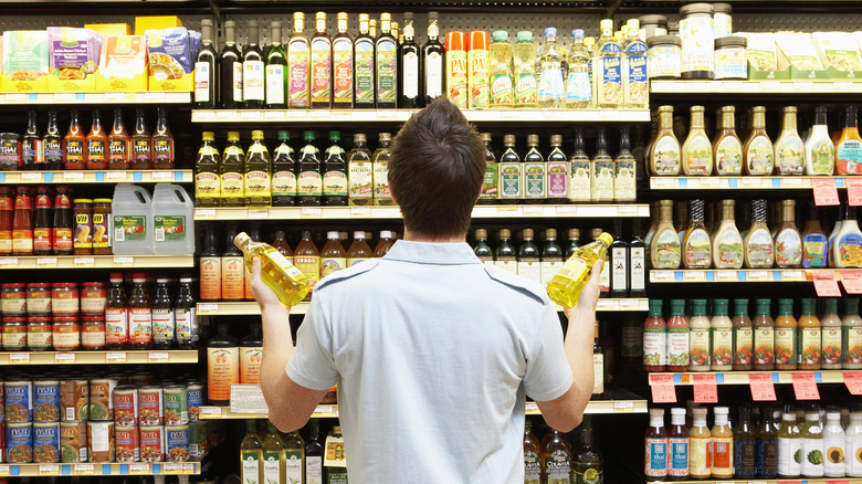 man deciding between cooking oils