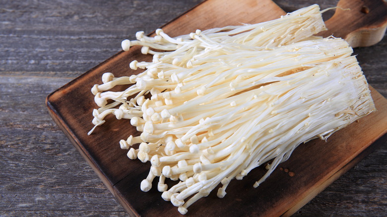 Enoki mushrooms on cutting board