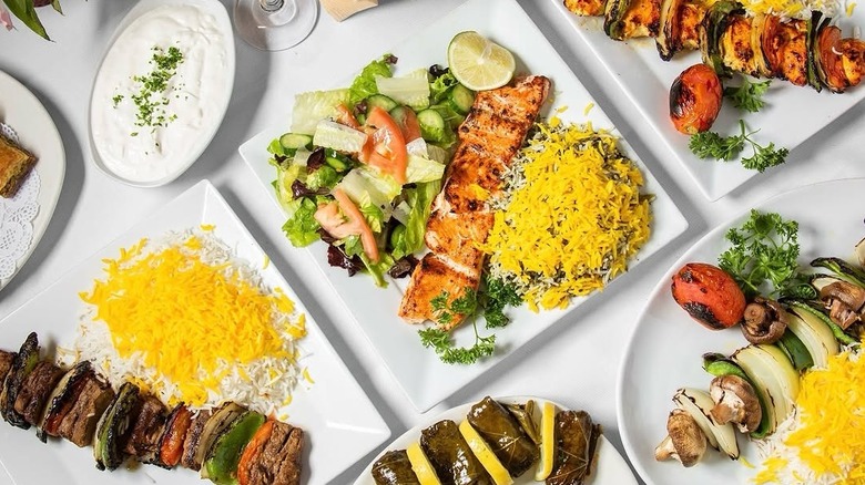 top down shot of a table with various persian rice and kebab dishes